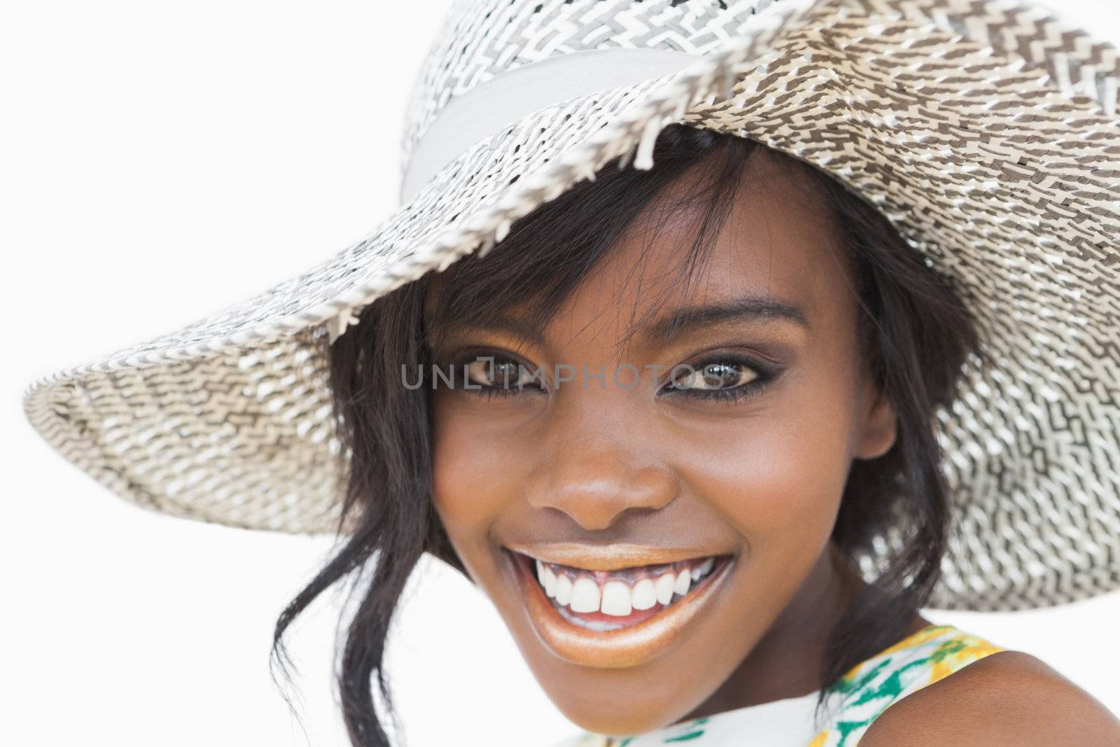 Woman wearing summer hat while smiling on white background