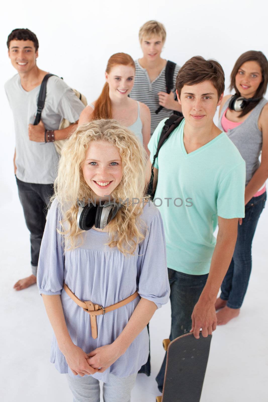 Happy teenagers smiling at the camera agaisnt white background with bags