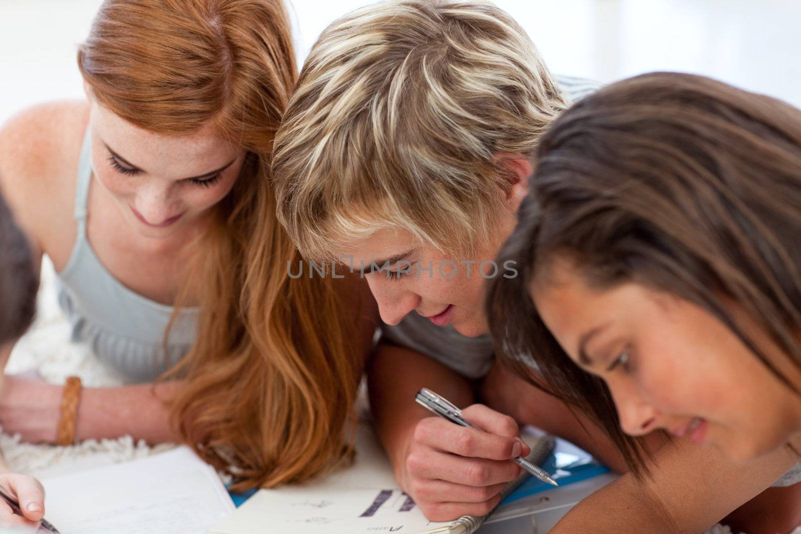 Portrait of a teenagers doing homework on the floor