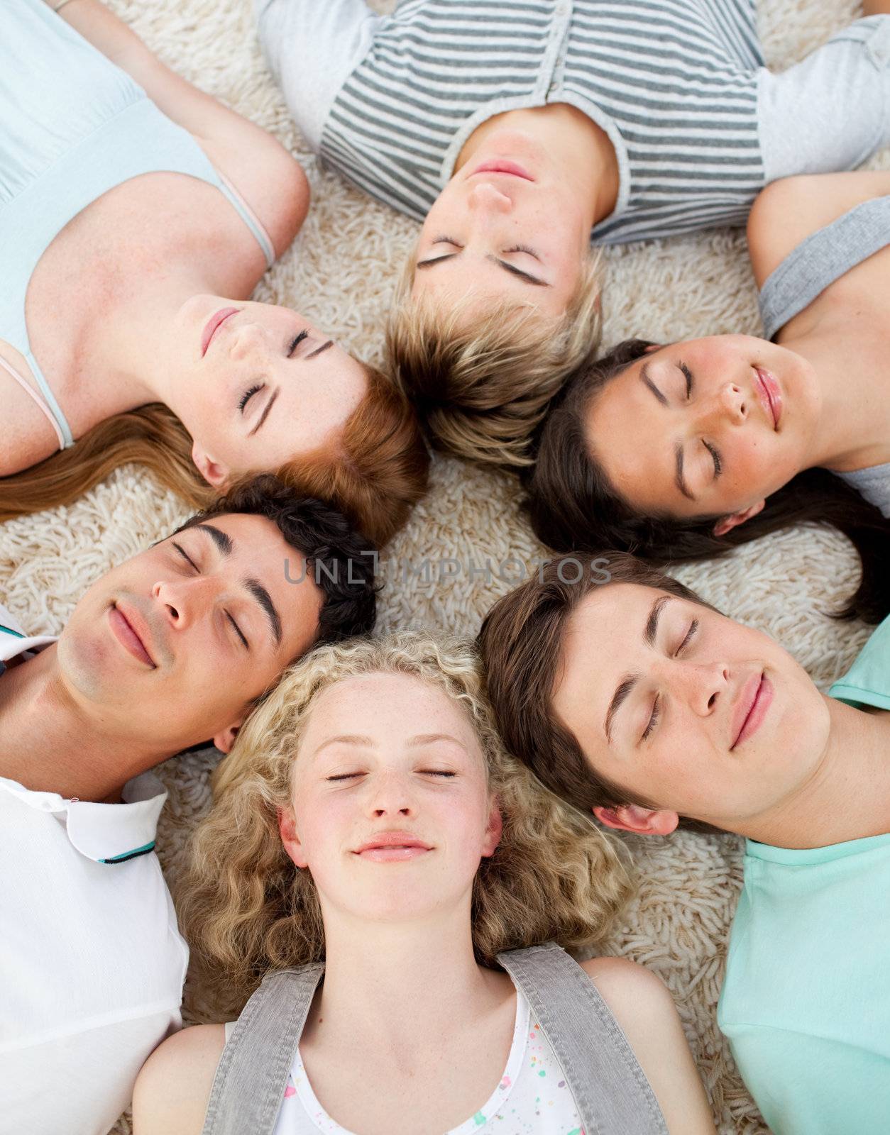 Friends with their heads together sleeping on the ground  by Wavebreakmedia