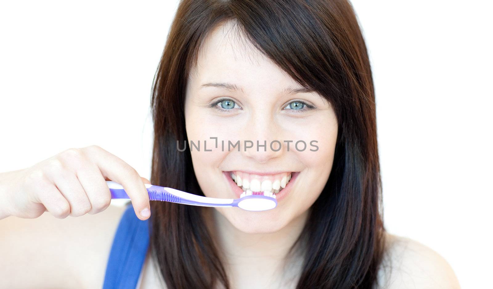 Smiling woman brushing her teeth against a white background