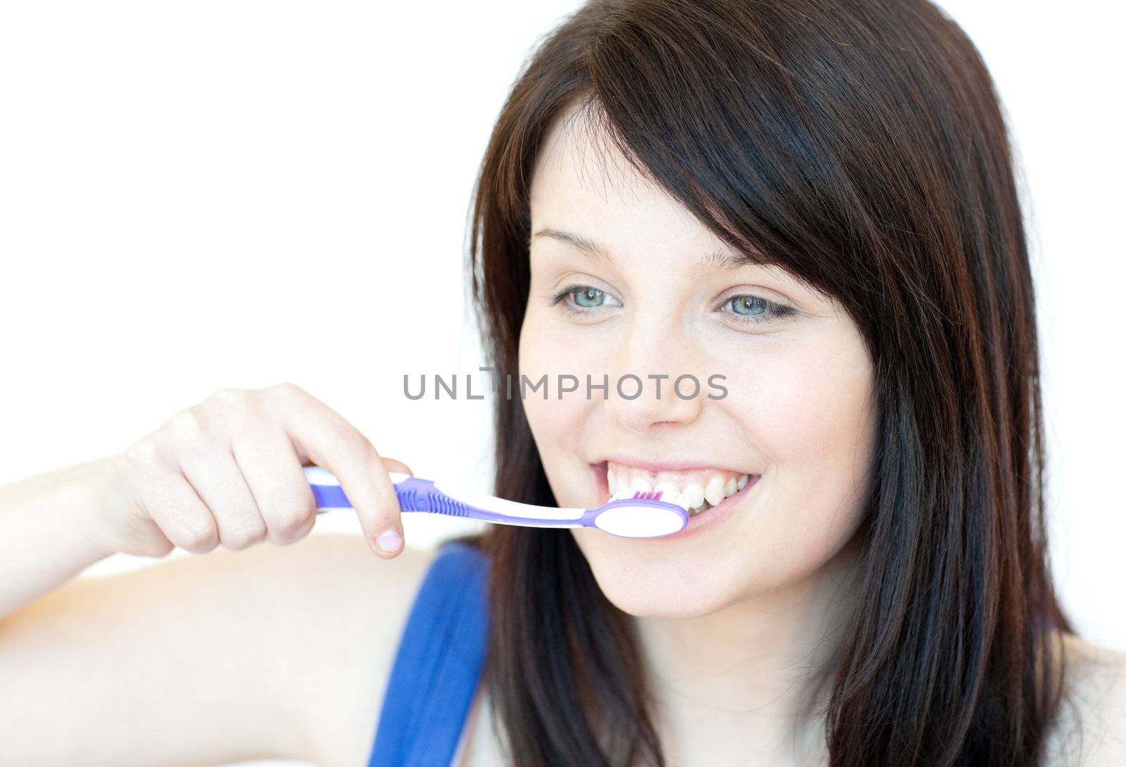 Jolly woman brushing her teeth against a white background