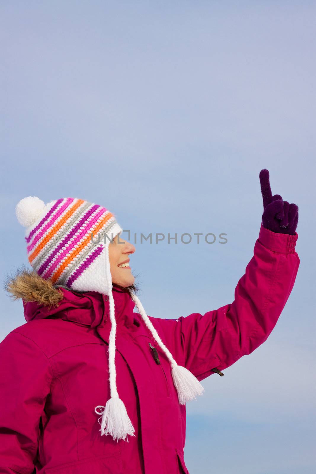 Girl in witer clothes pointing upwards by Harvepino