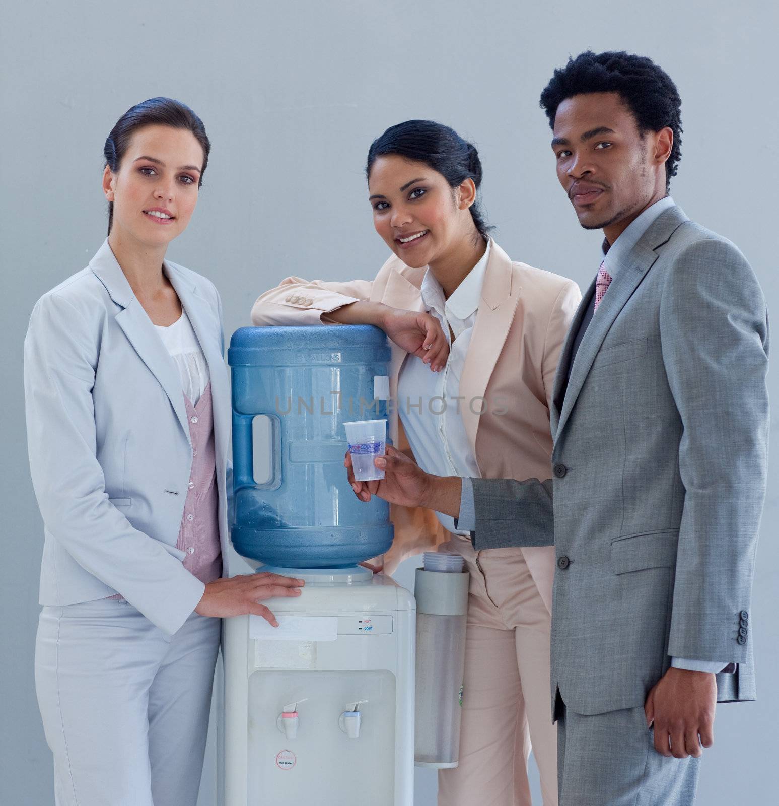 Business people speaking next to a water cooler in office