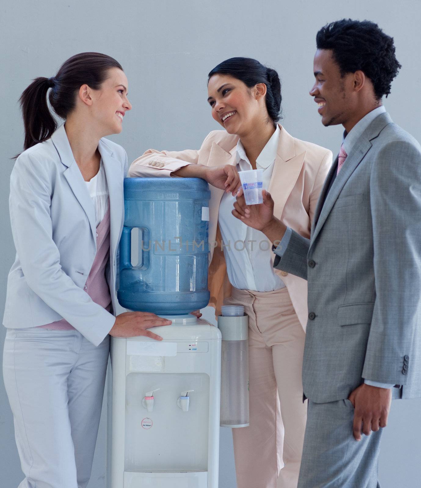 Business people speaking next to a water cooler by Wavebreakmedia
