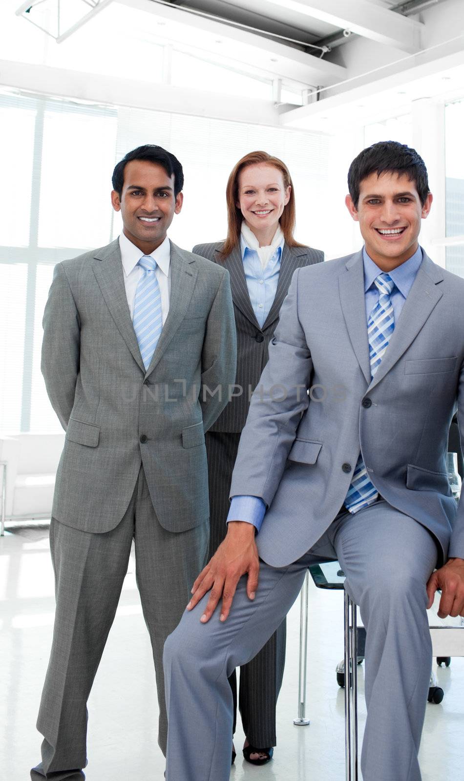 Business people in a line smiling at the camera in the office