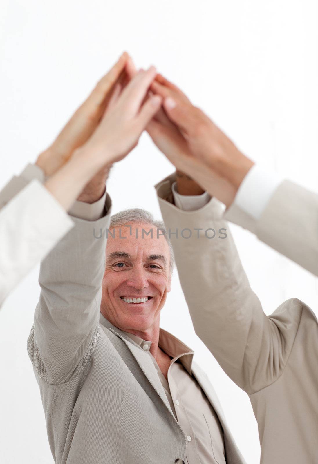 Smiling businessman joining hands with his team isolated on a white background