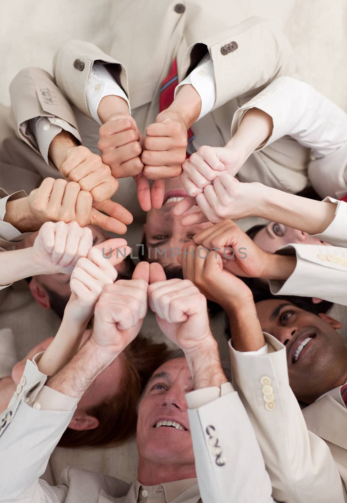 Multi-ethnic business people with thumbs up lying on the floor by Wavebreakmedia