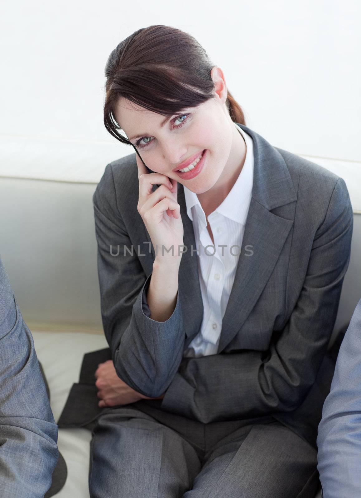 Attractive businesswoman on phone sitting in a waiting room