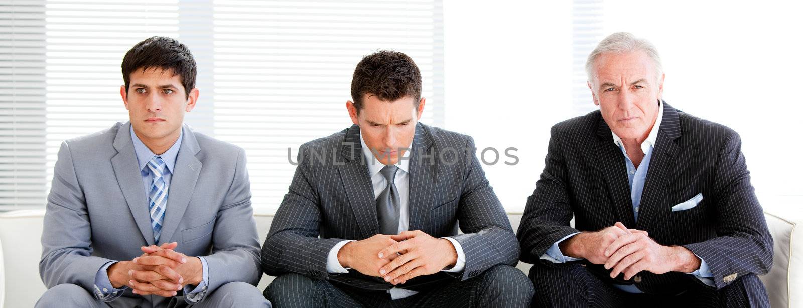 Three charismatic businessmen in a waiting room by Wavebreakmedia