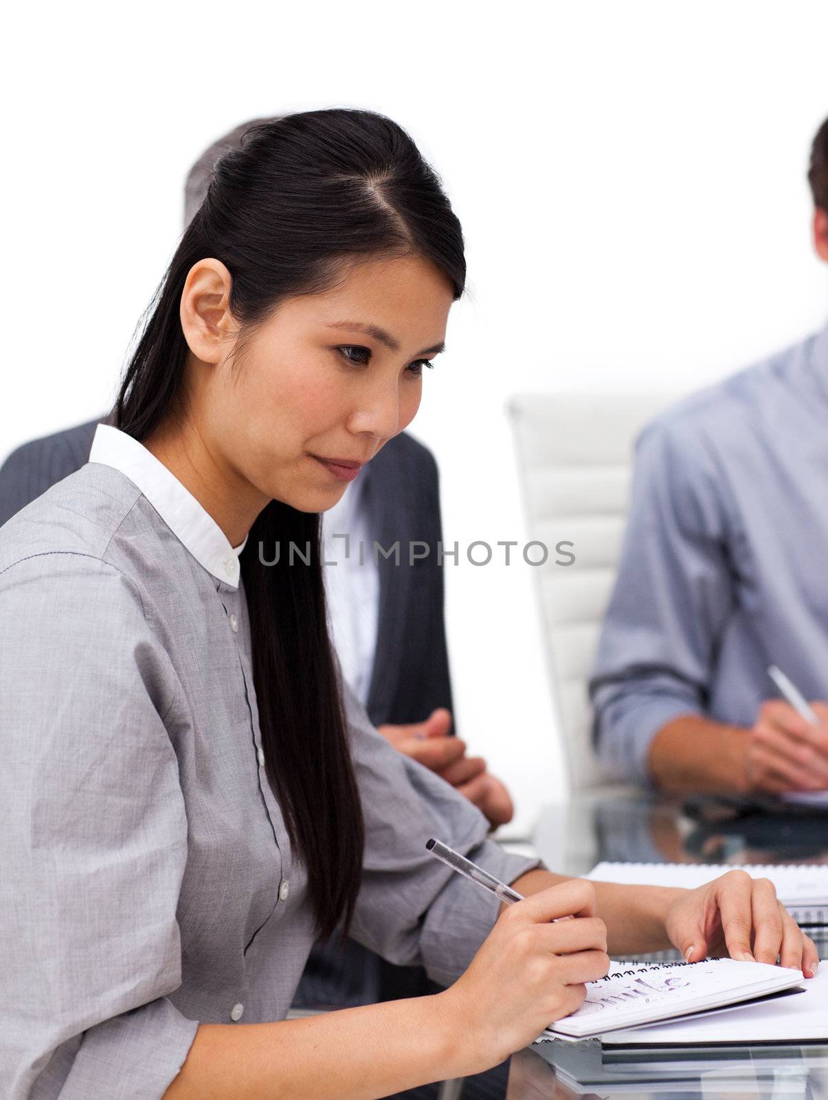 Concentrated female executive studying a document in a meeting