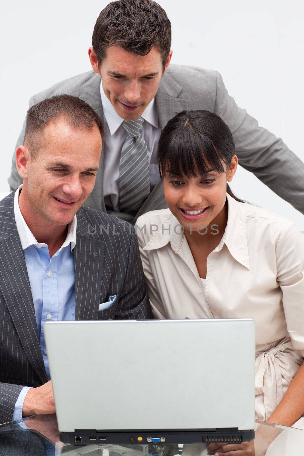 Two businessmen and a businesswoman using a laptop in the office