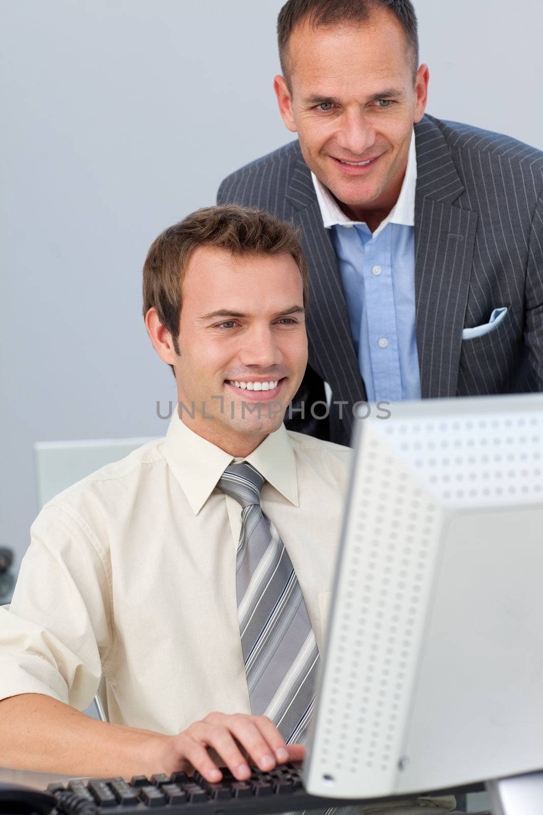 Mature manager checking his employee's work in the office