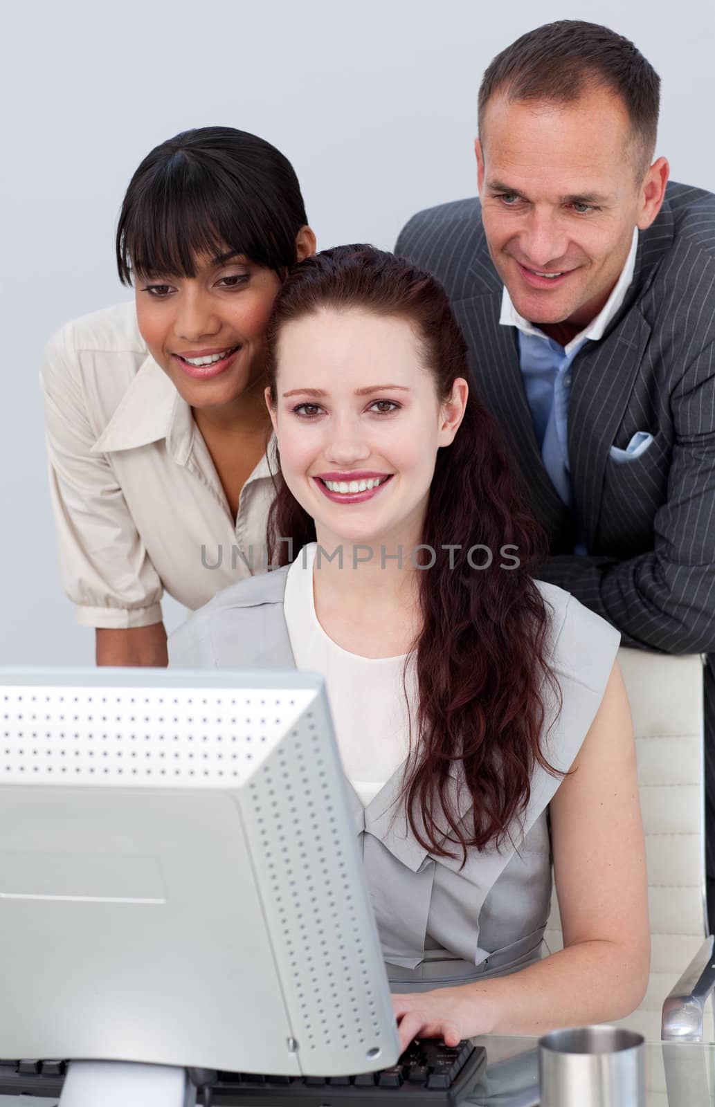 Smiling international Business people working together at a computer

