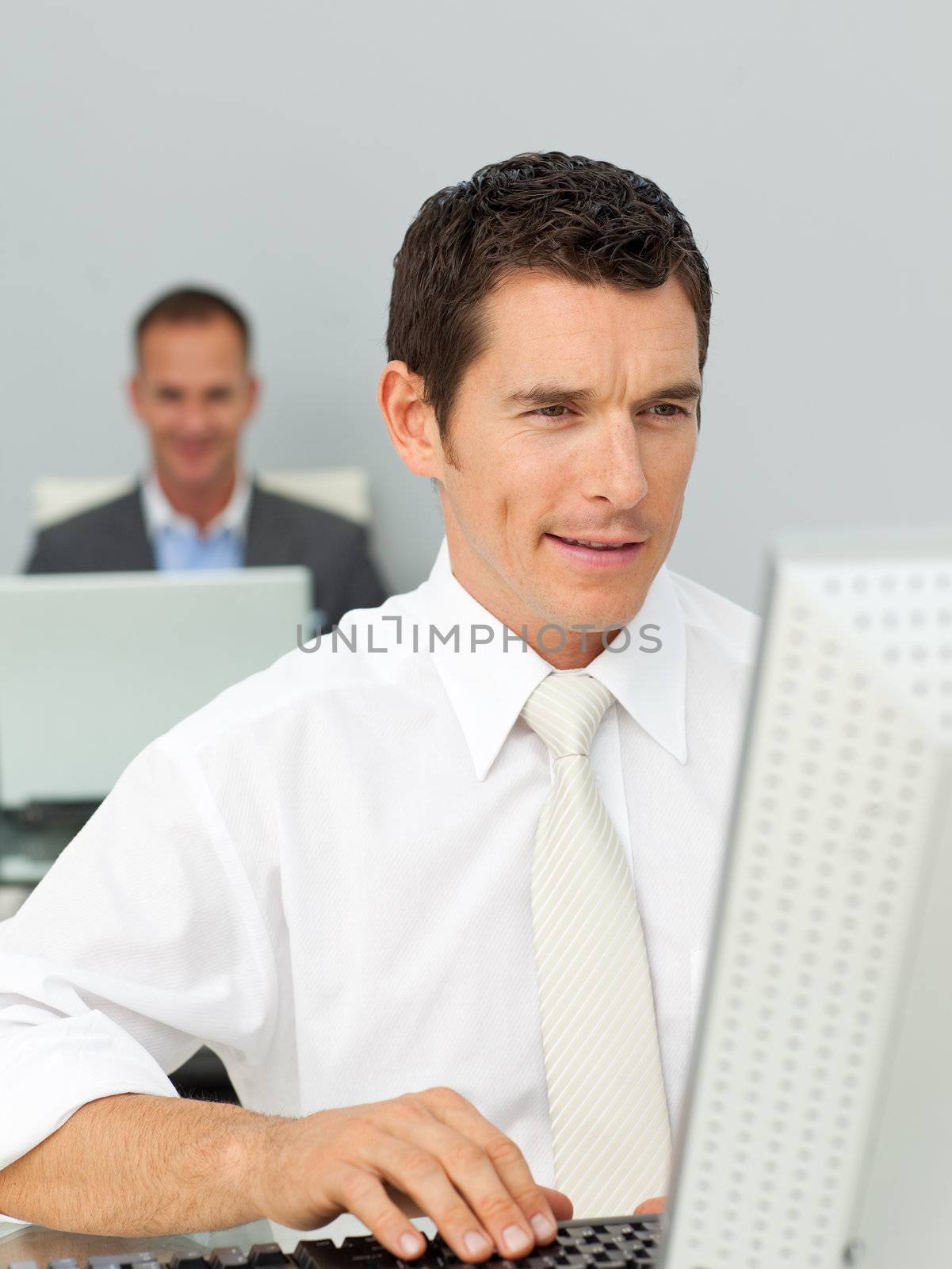 Smiling businessman working at his computer  by Wavebreakmedia