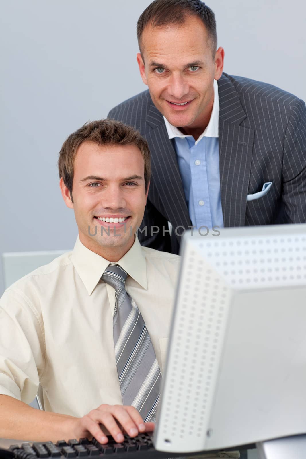 Assertive business partners working together at a computer in the office