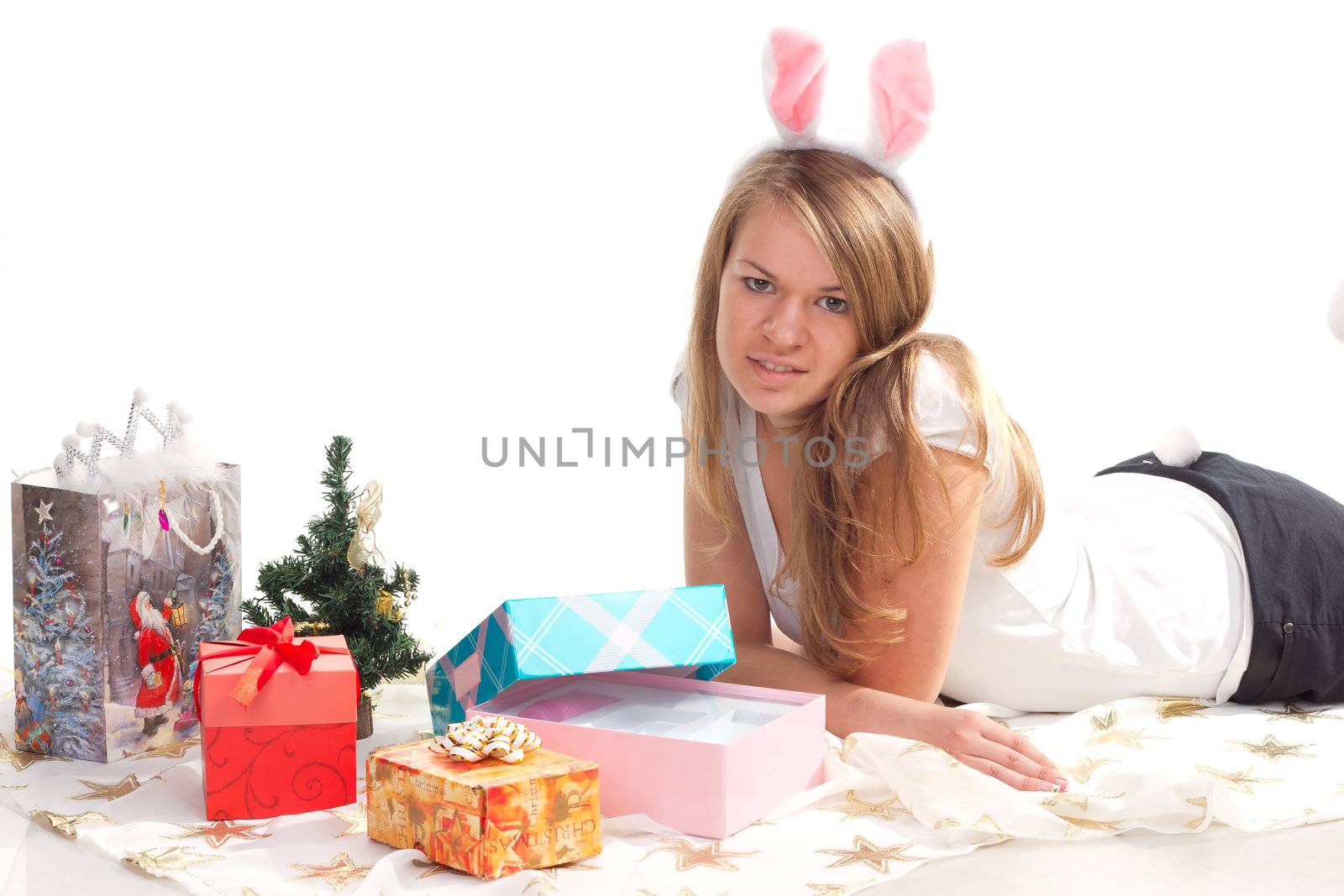 girl lying beside Christmas presents studio shooting