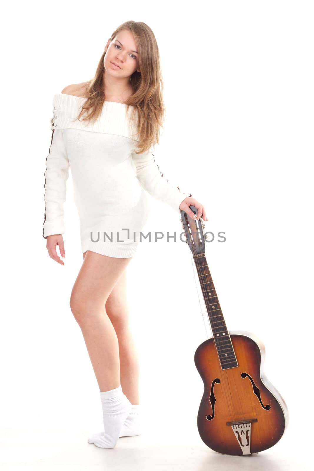 Beautiful girl in sweater with a guitar studio photography