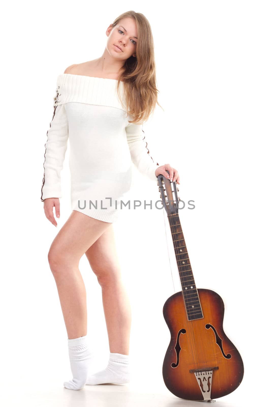 Beautiful girl in sweater with a guitar studio photography