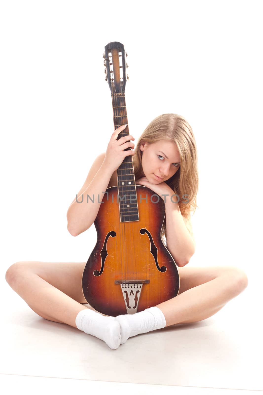 Beautiful girl in sweater with a guitar studio photography