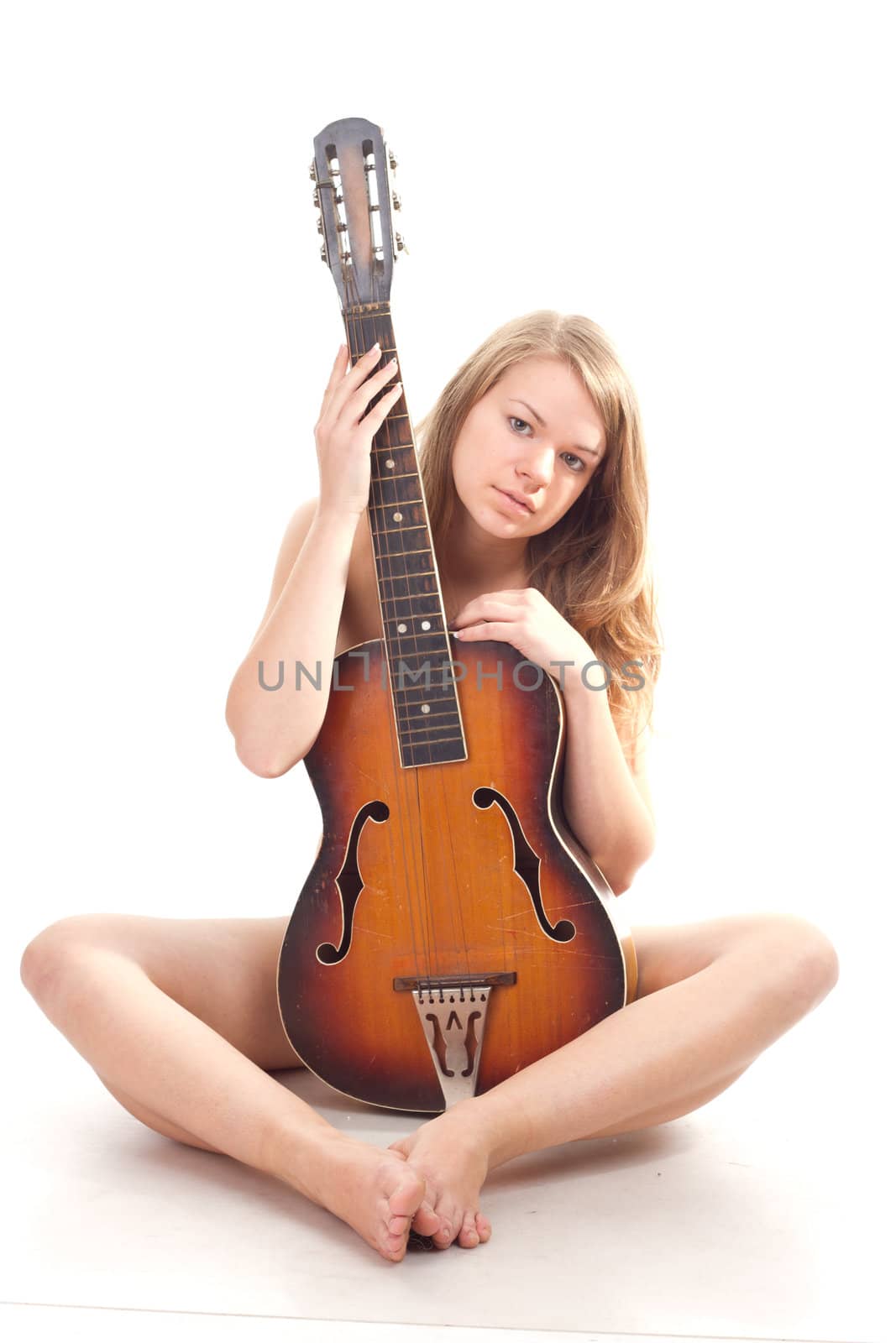 Beautiful girl in sweater with a guitar studio photography