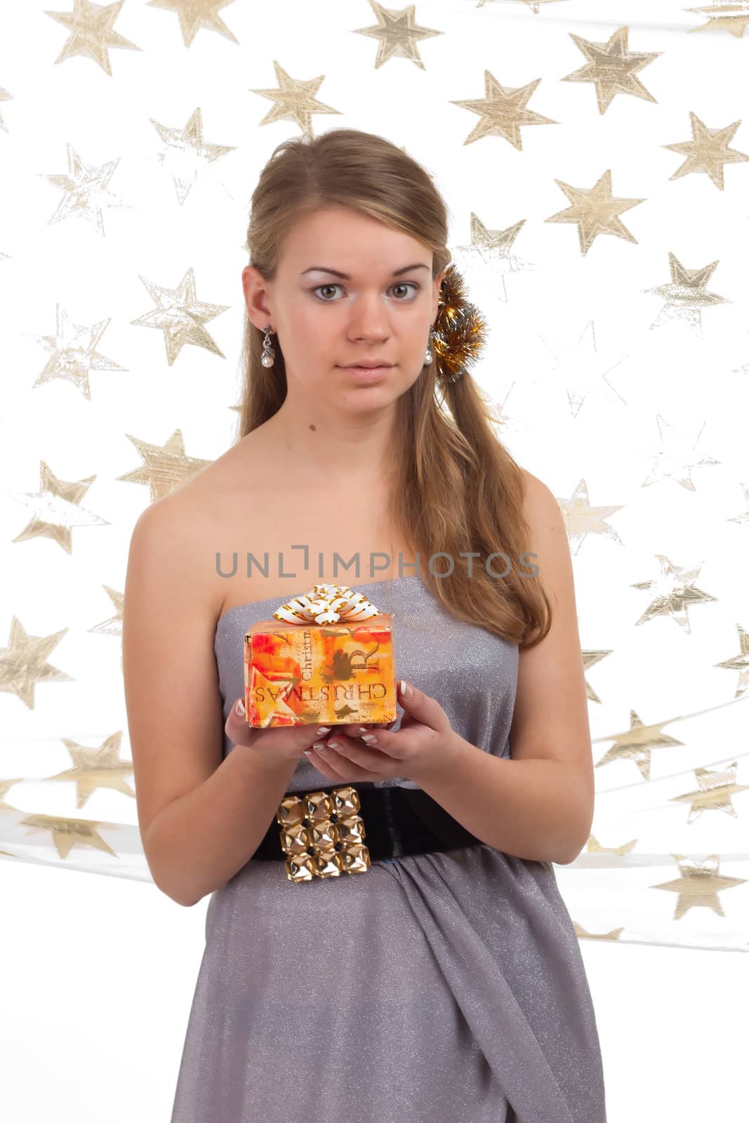 girl celebrates Christmas with a gift in the hands of studio photography