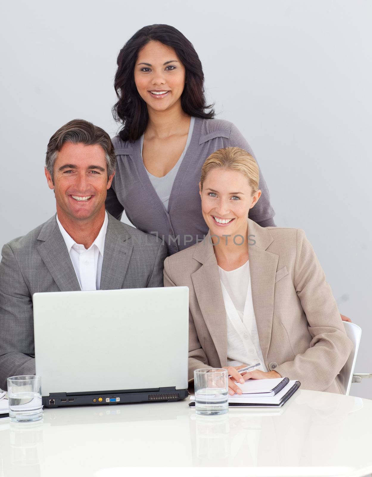 Smiling business team working with a laptop in the office