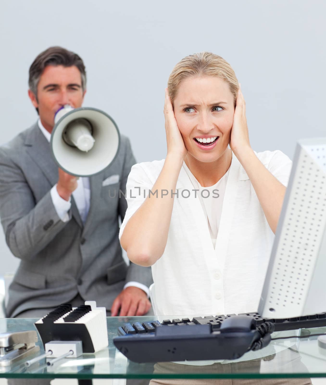 Charismatic manager yelling through a megaphone in his colleague by Wavebreakmedia