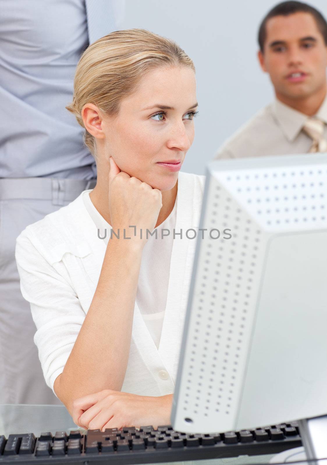 Pensive blond woman working at a computer in the office