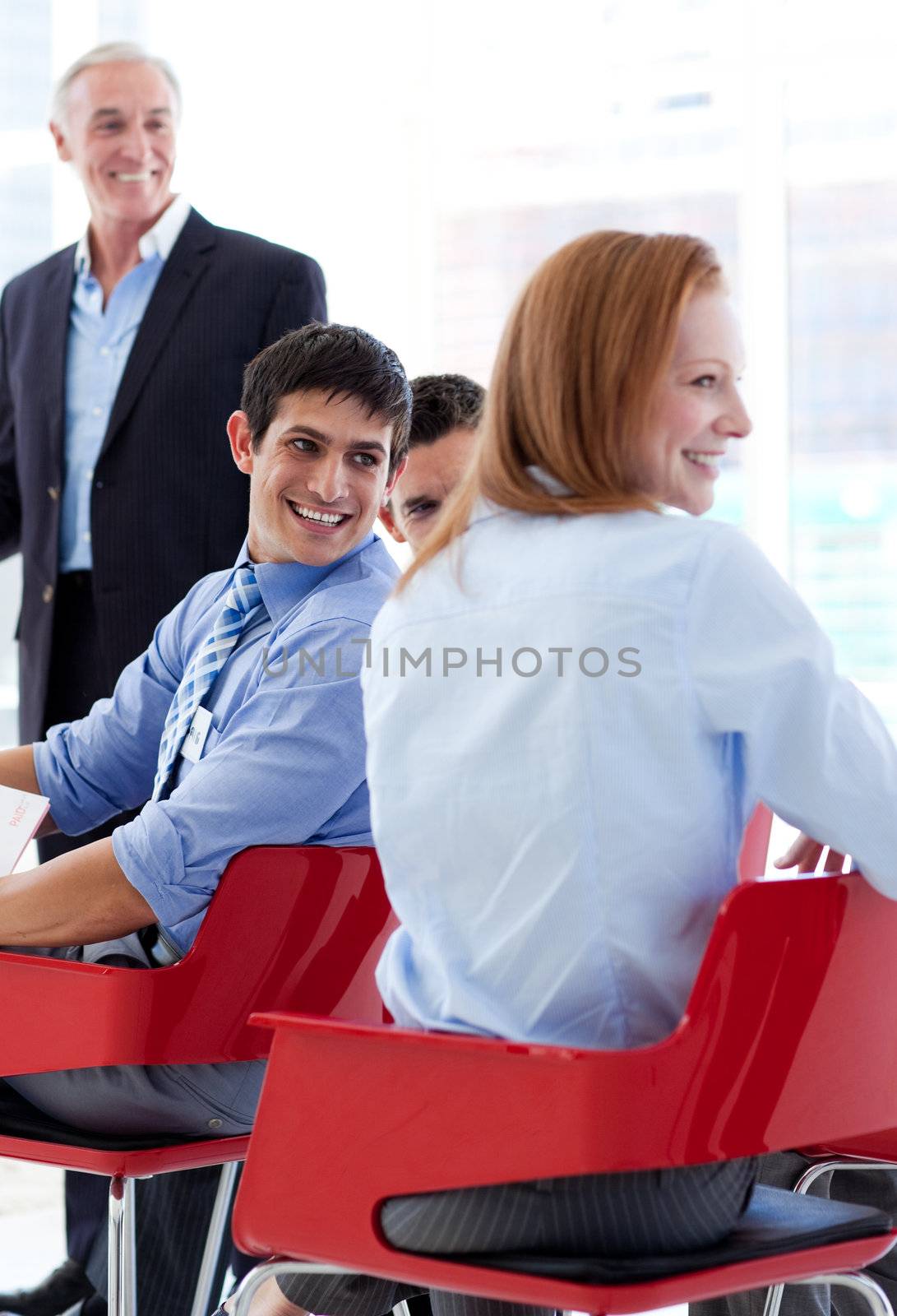 Smiling business people discussing at a conference by Wavebreakmedia