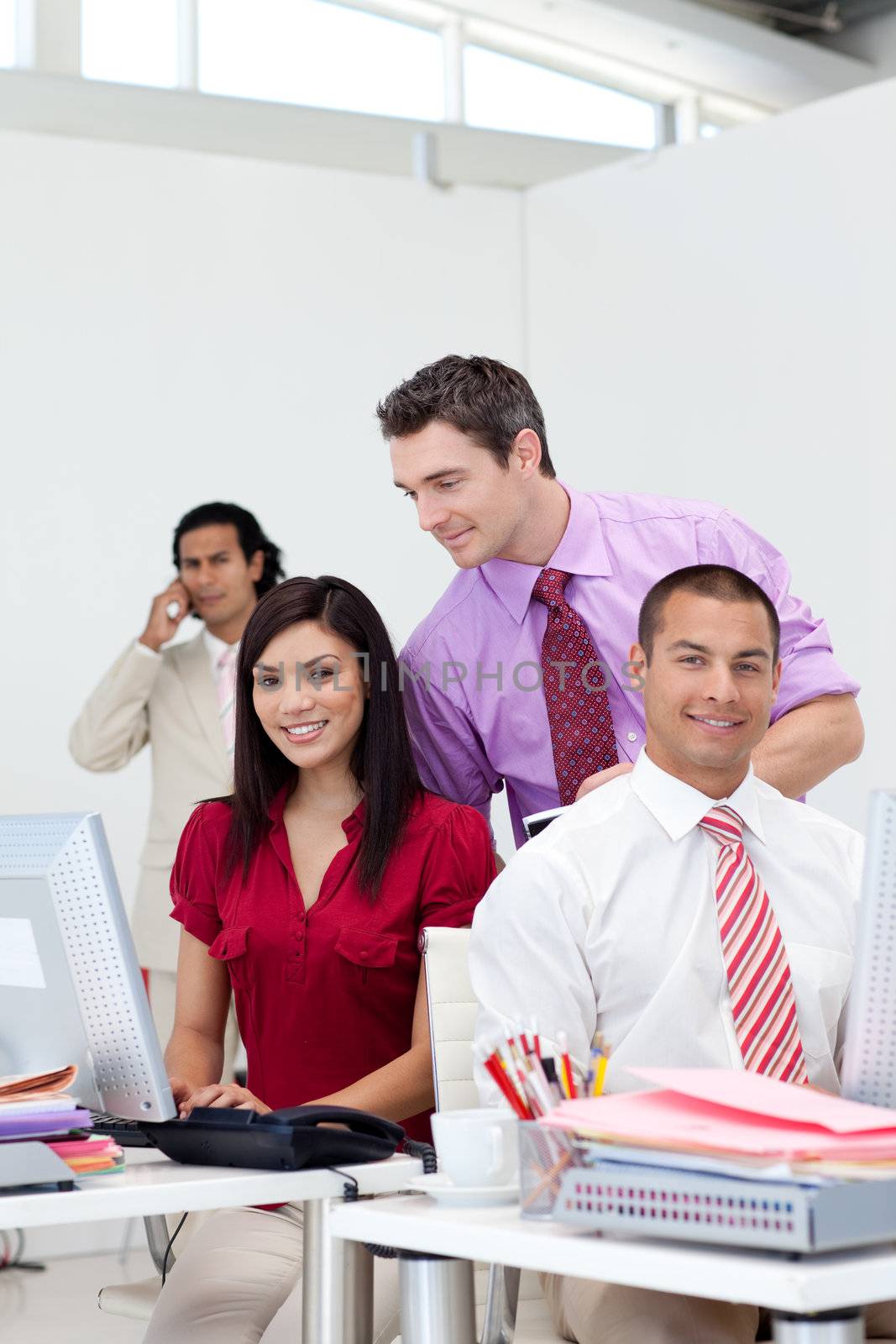 Smiling manager checking his team work in the office