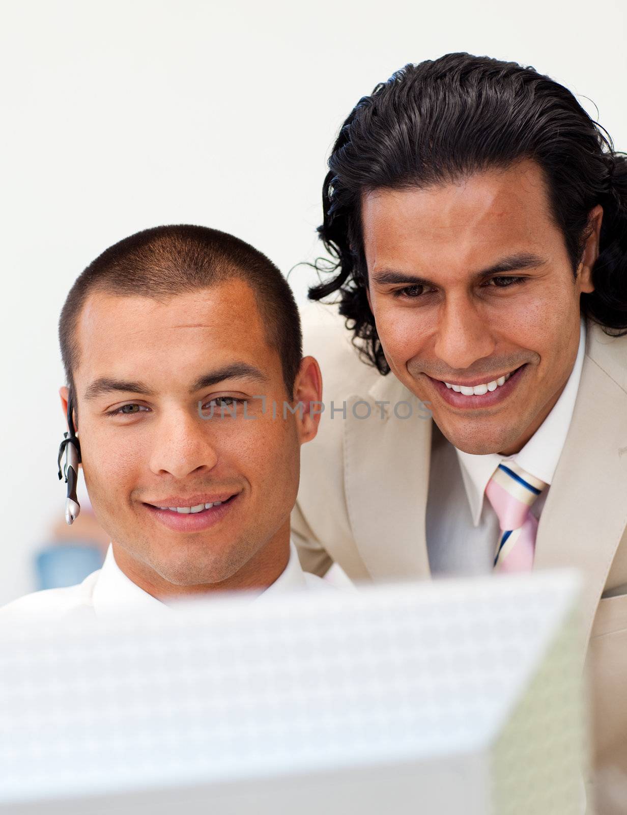 Two colleagues looking at a computer in the office