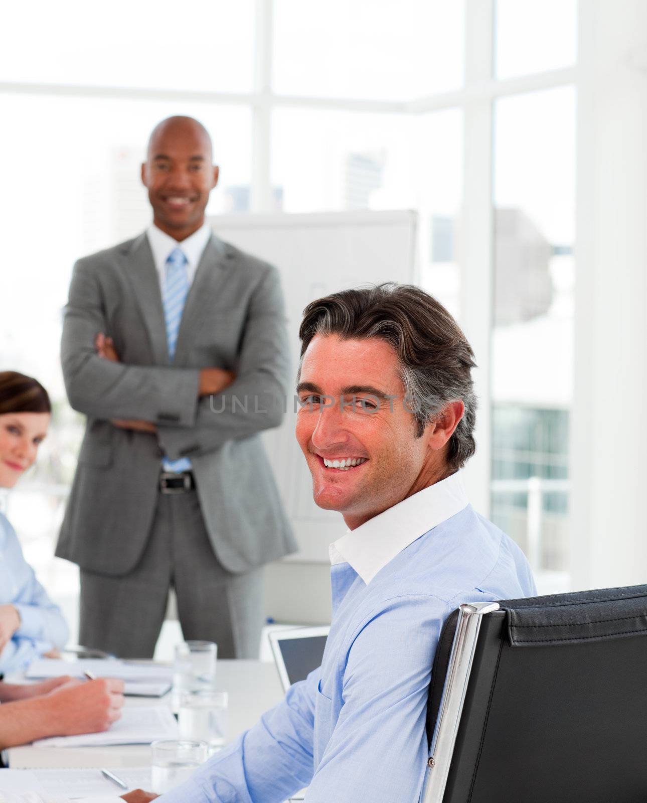 Businessmen in a meeting with their team smiling at the camera