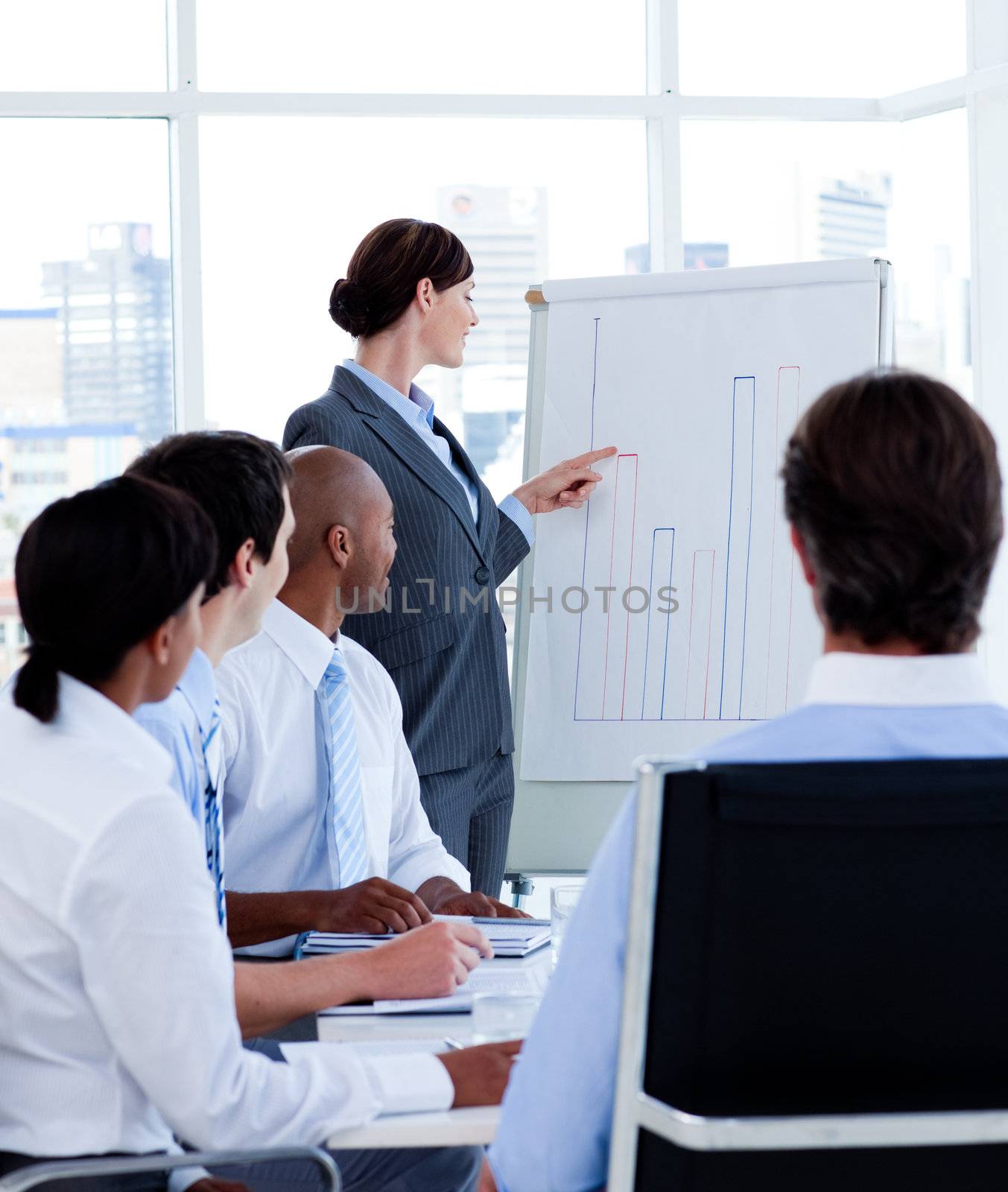 Confident manager reporting sales figures to her team at a meeting