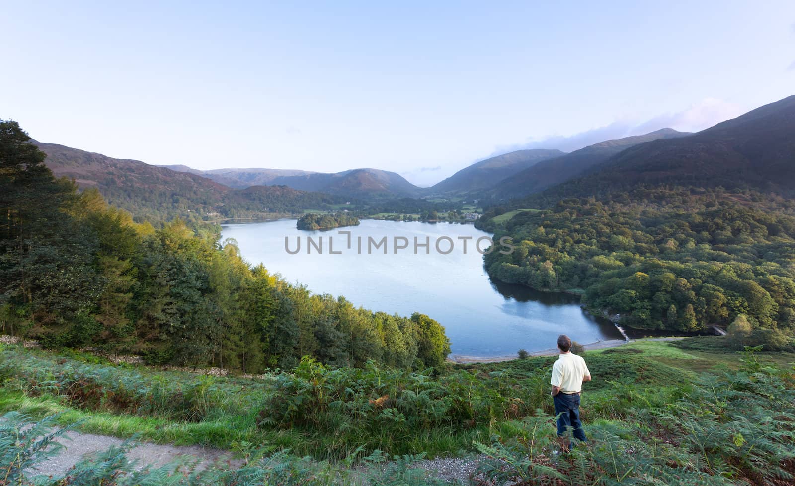 Hiker at Grasmere at dawn in Lake District by steheap