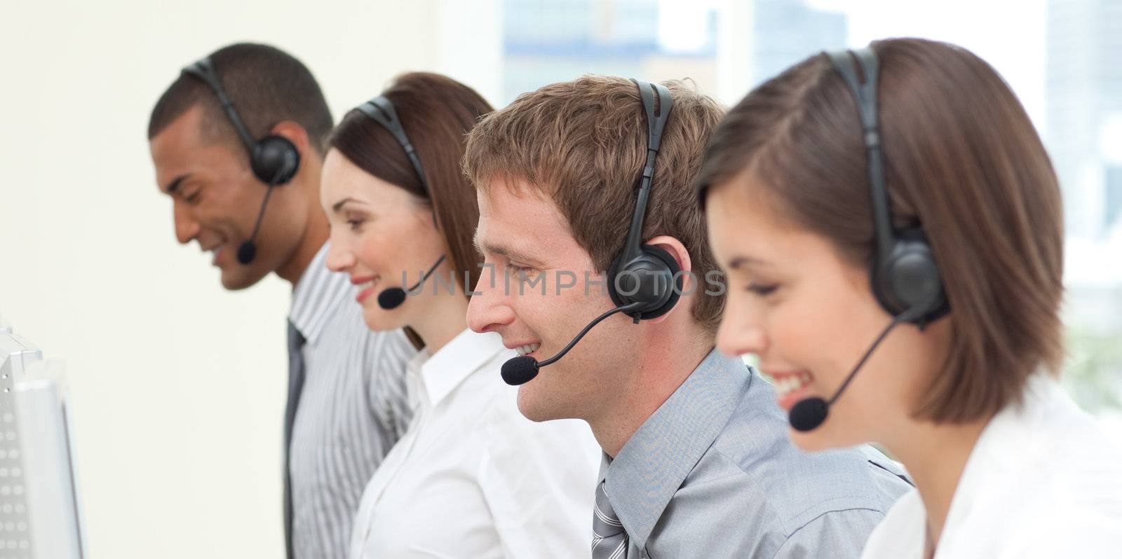 Serious co-workers with headset on in a call center