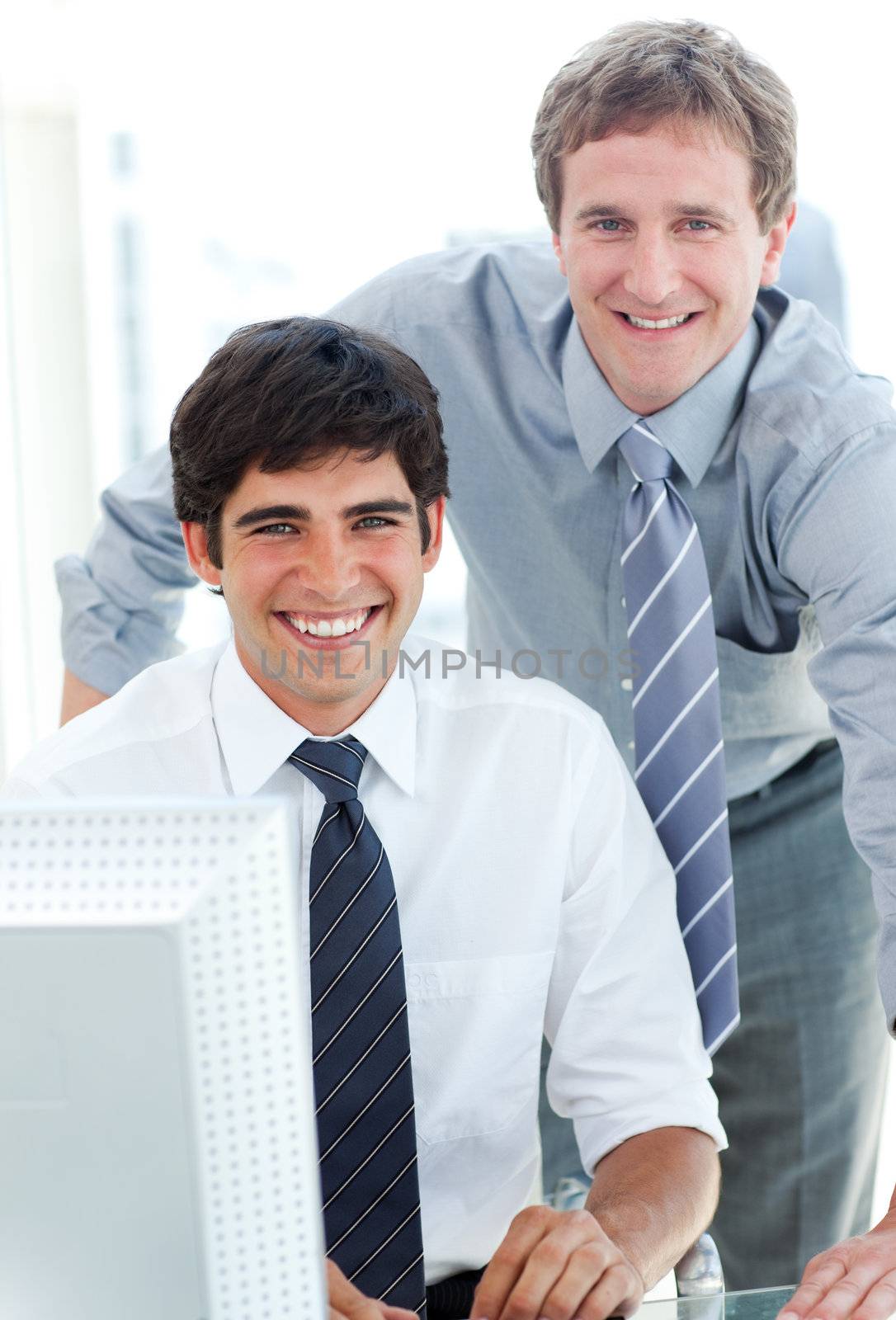 Two male executives working at a computer in the office