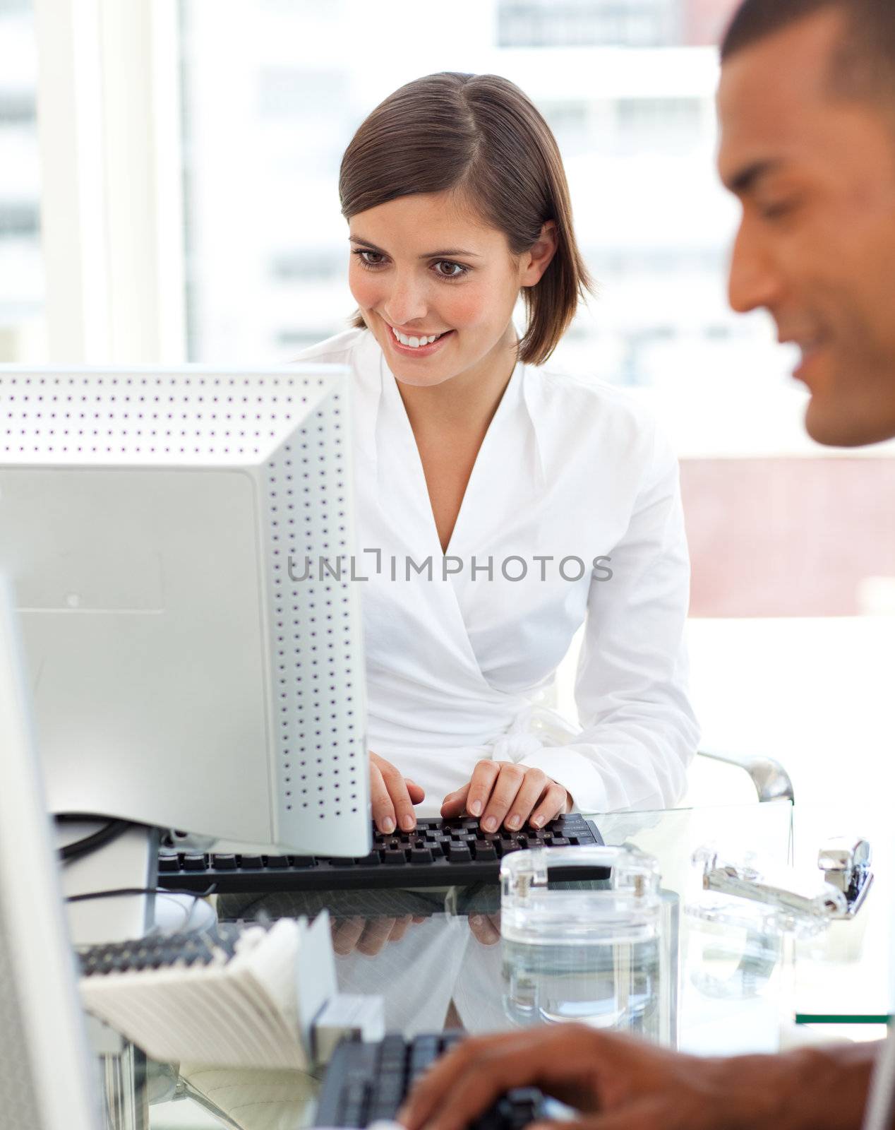 Two colleagues working at a their computer in the office