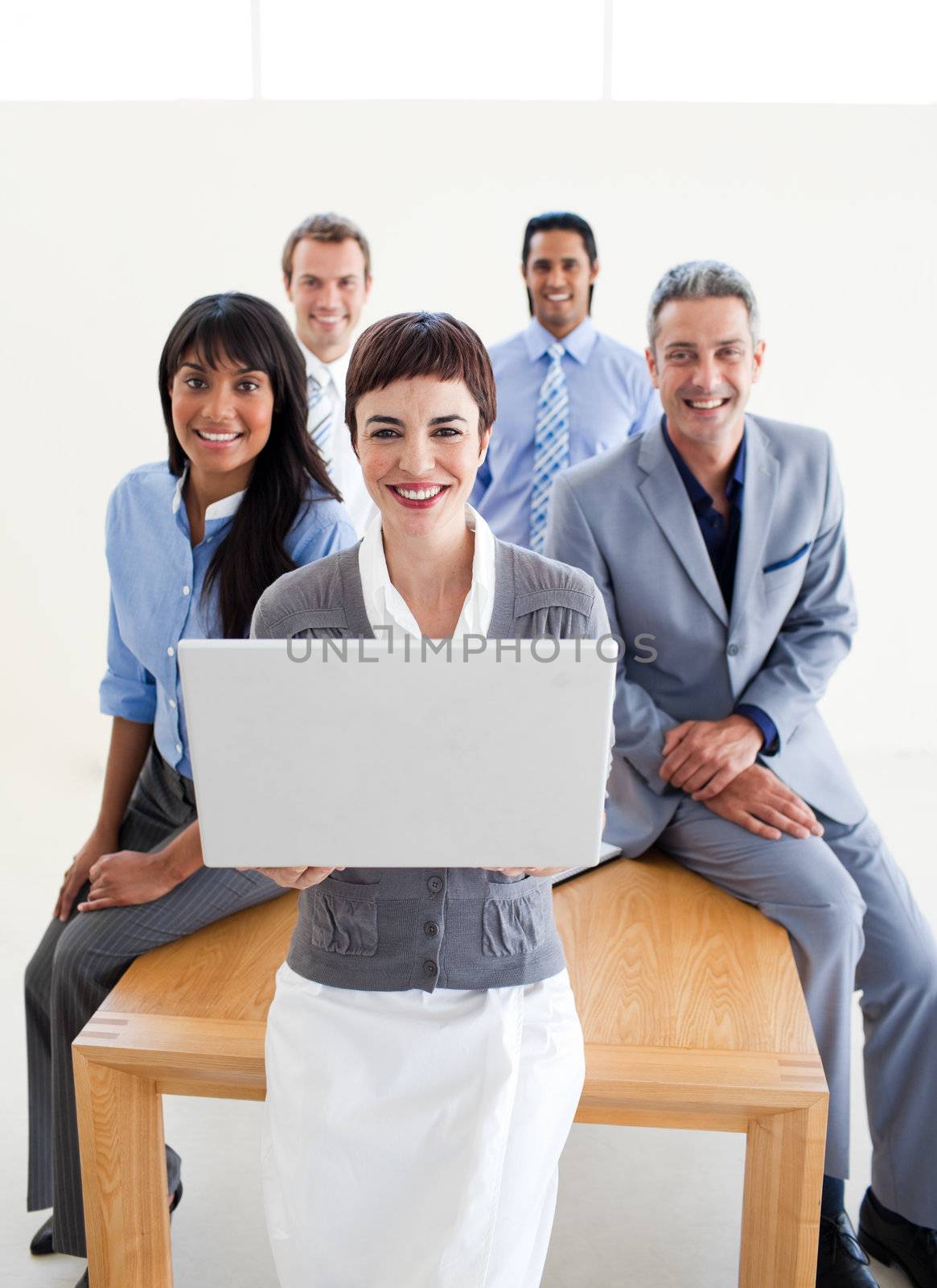 Smiling business people using a laptop by Wavebreakmedia