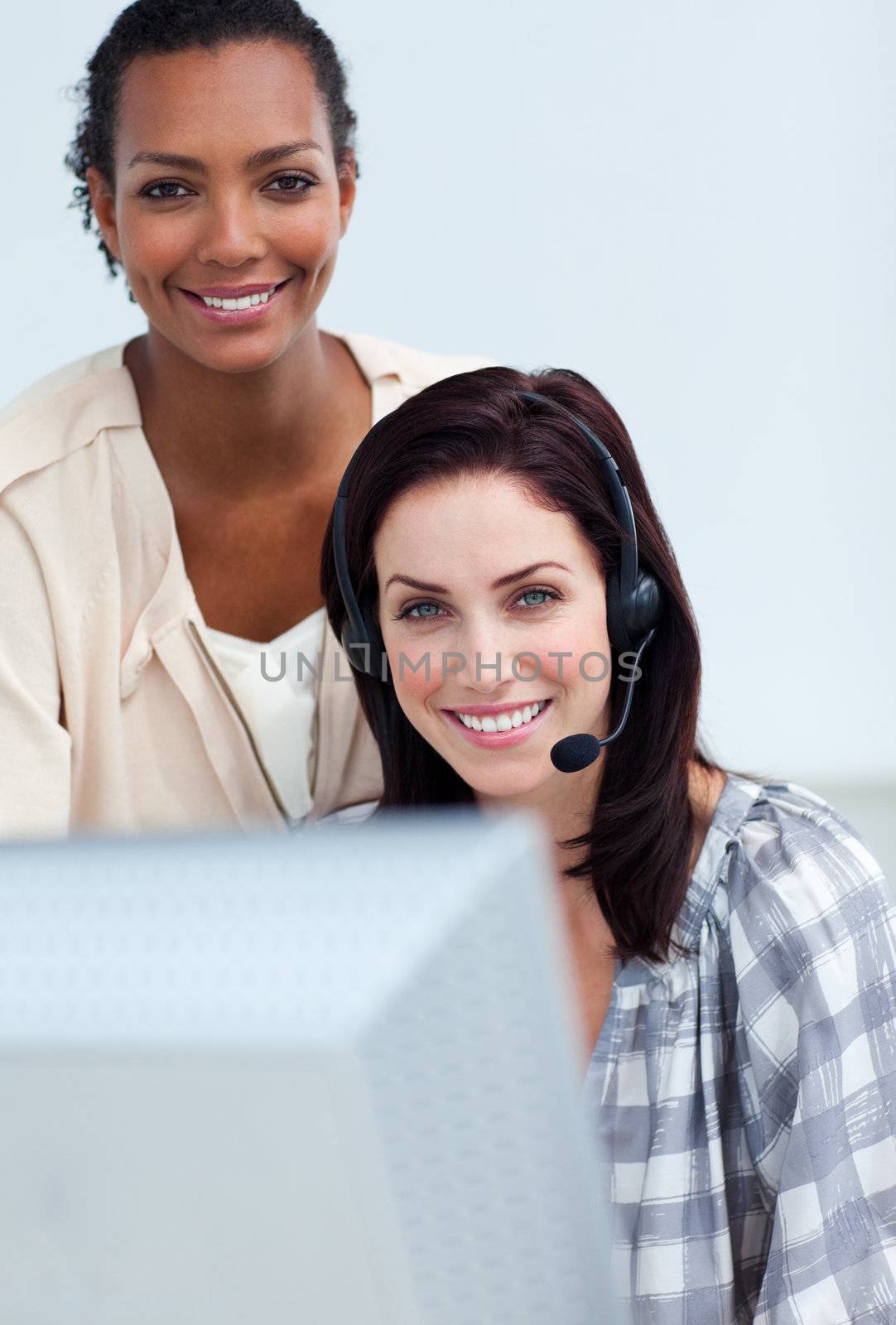 Afro-american businesswoman helping her colleague at a computer 