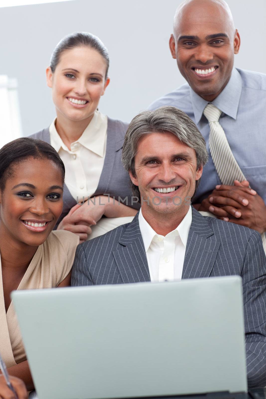 Confident Multi-ethnic business team working at a laptop in a meeting