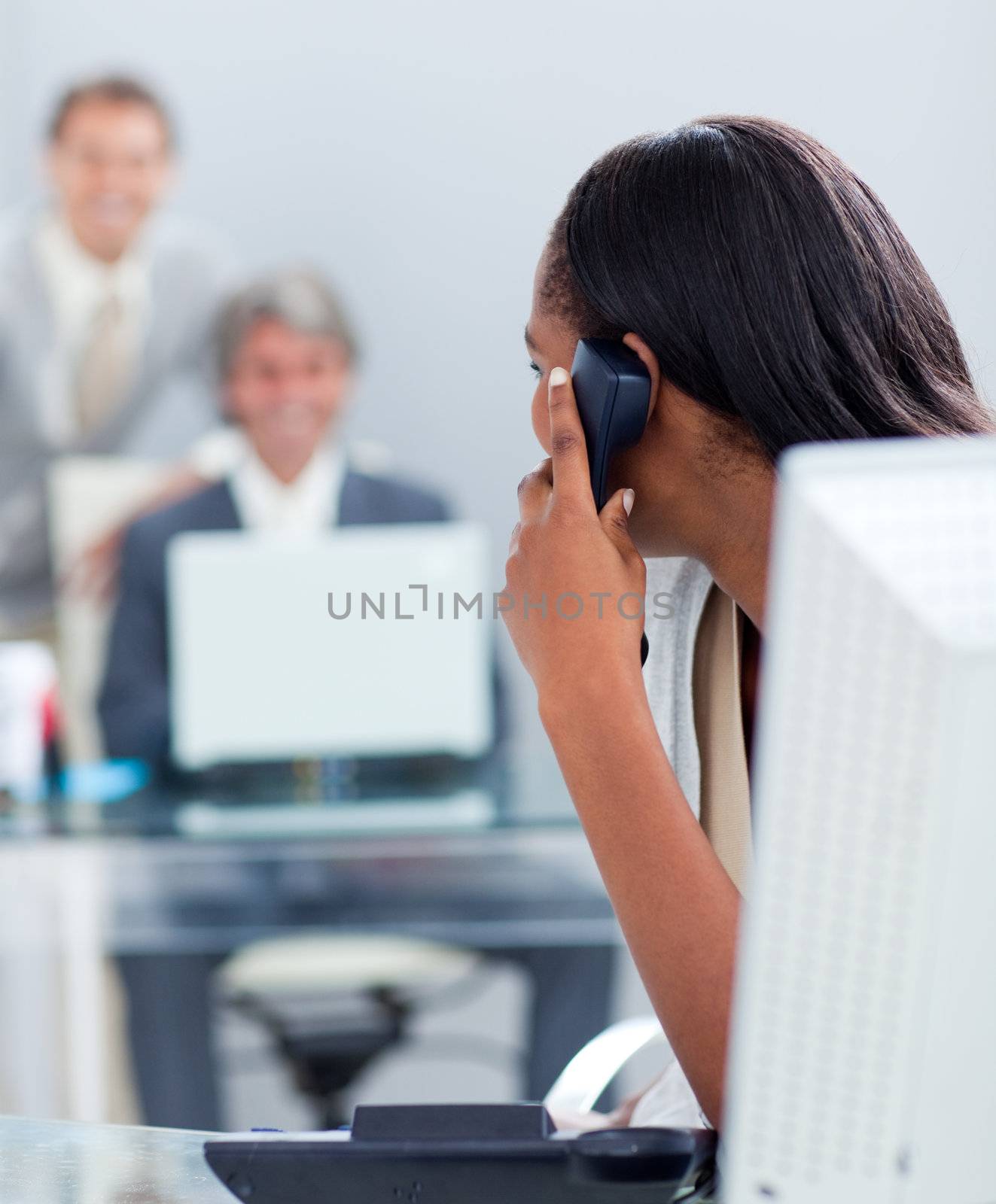 Afro-american businesswoman on phone at her desk in the office