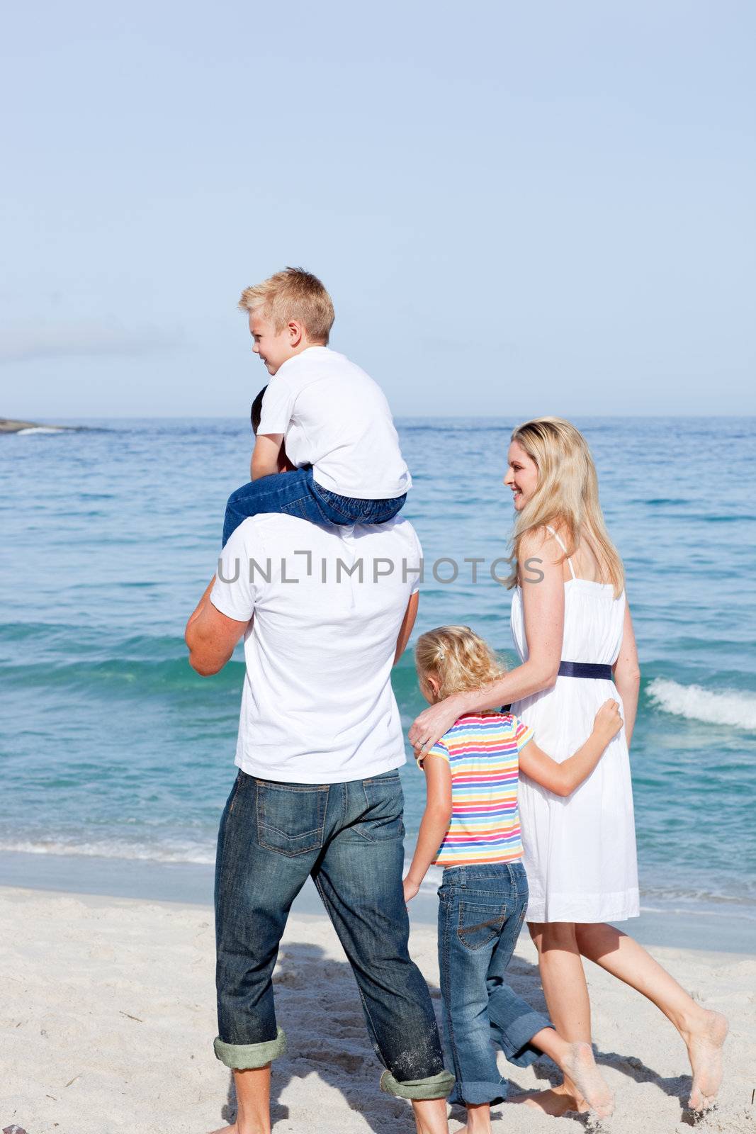 Affectionate family walking on the sand at the beach