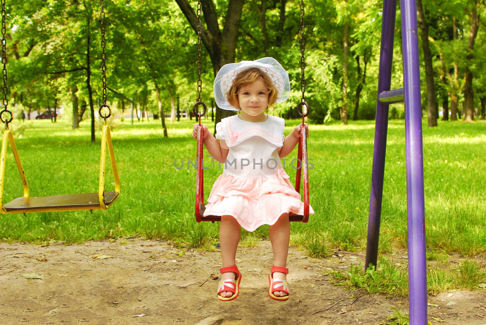 Beauty little girl sitting on the swing