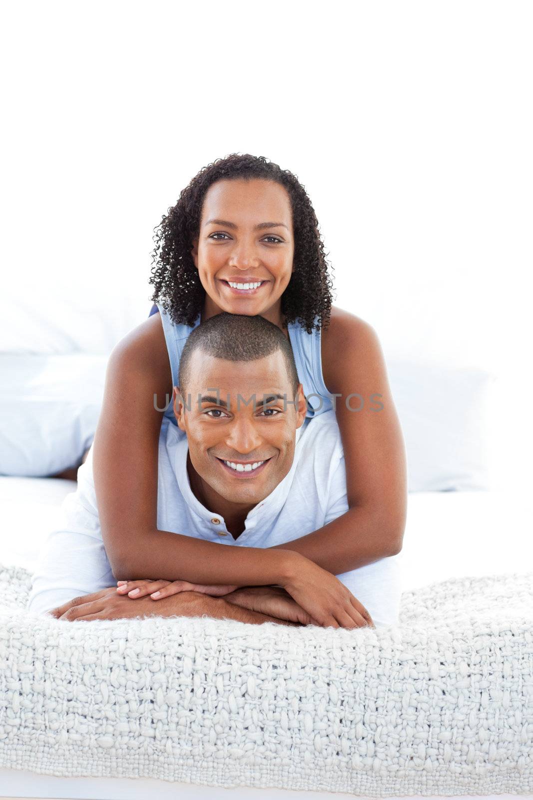 Portrait of a romantic couple cuddling lying down on bed at home