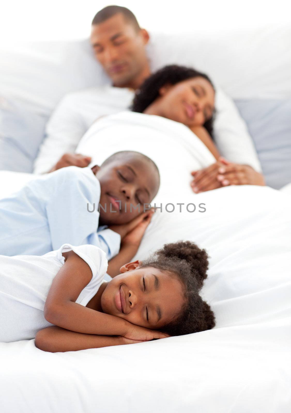 Jolly family sleeping lying on a bed