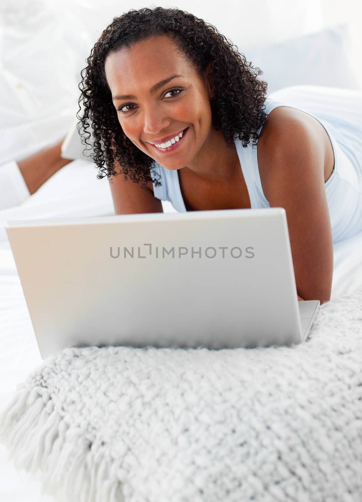 Cheerful woman using a laptop on her bed by Wavebreakmedia