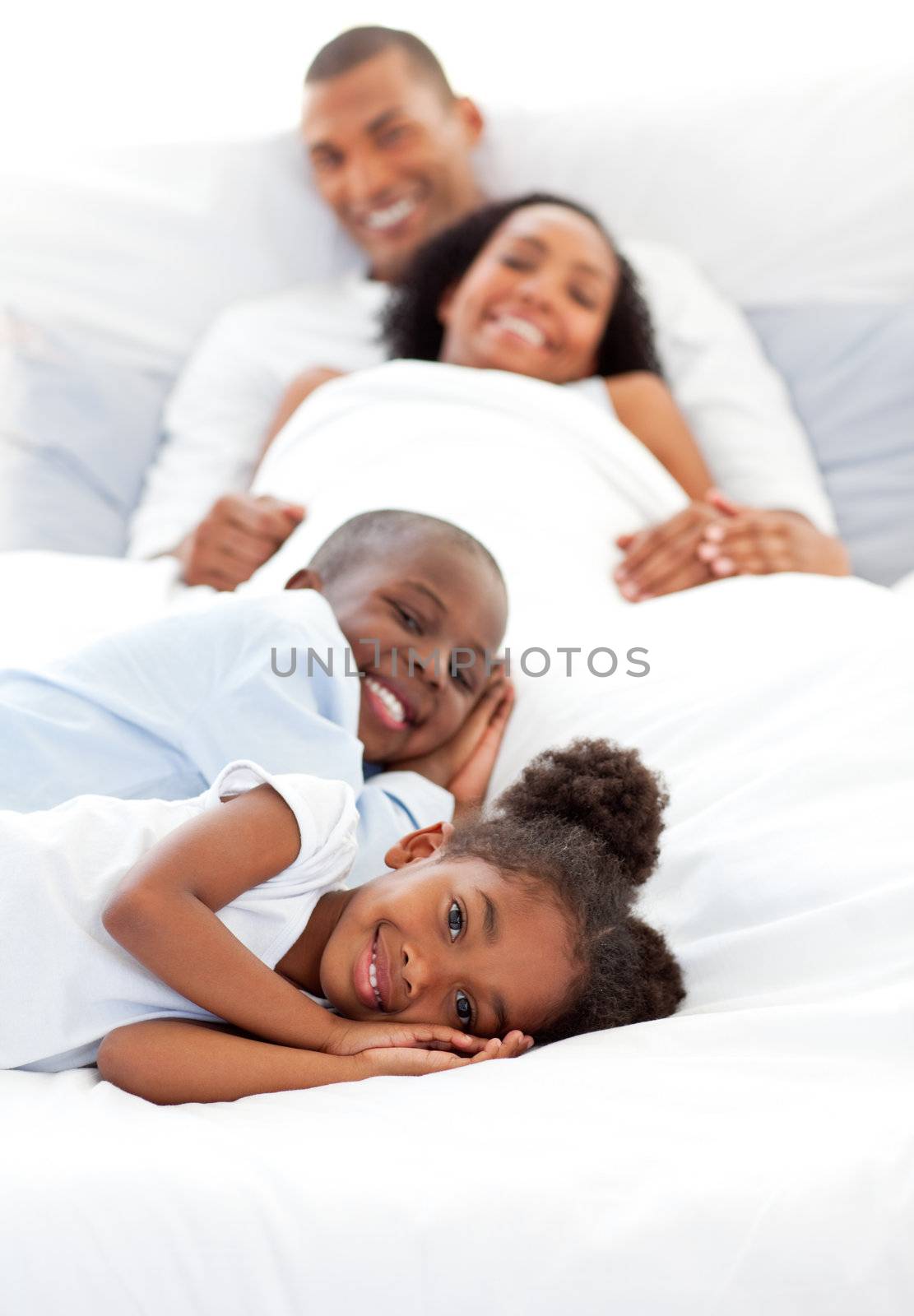 Smiling family having fun lying on a bed