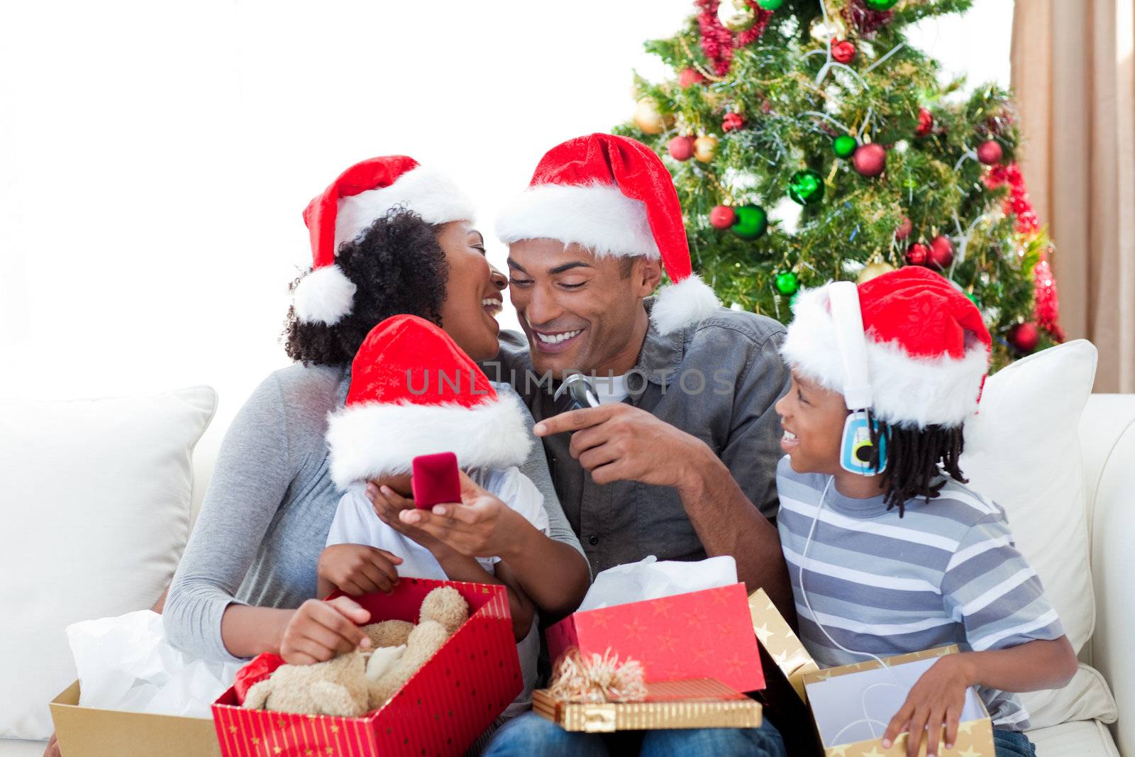 Happy Afro-American family having fun with Christmas presents by Wavebreakmedia