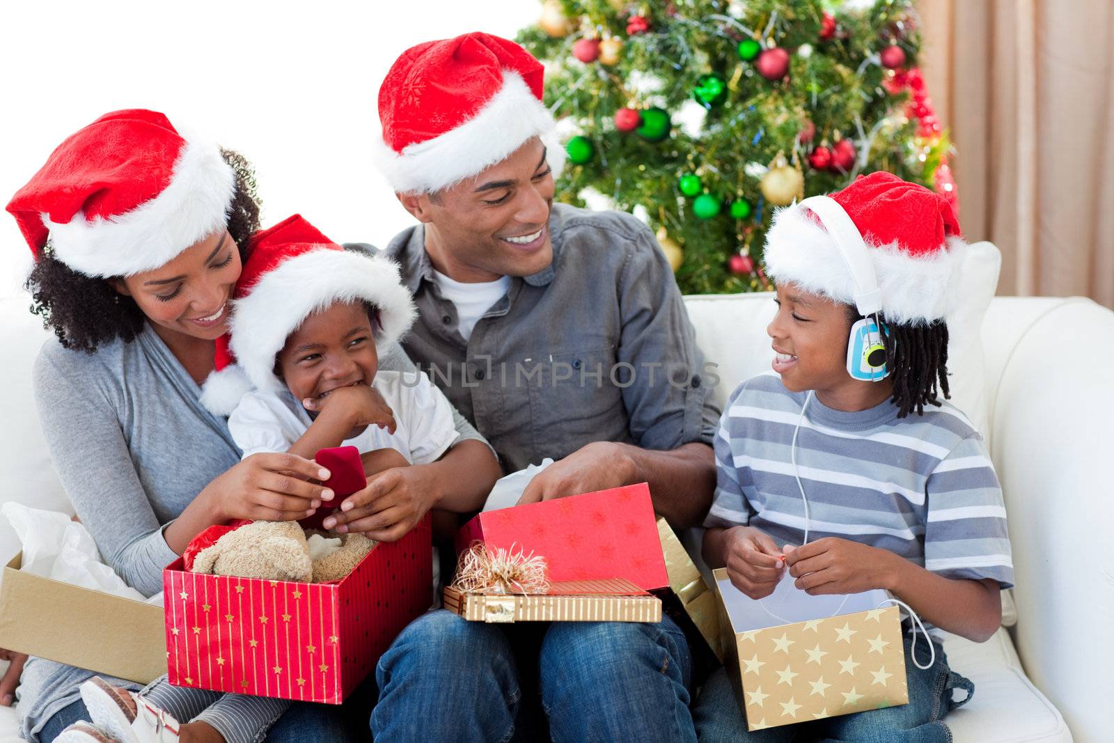 Happy Afro-American family opening Christmas presents by Wavebreakmedia